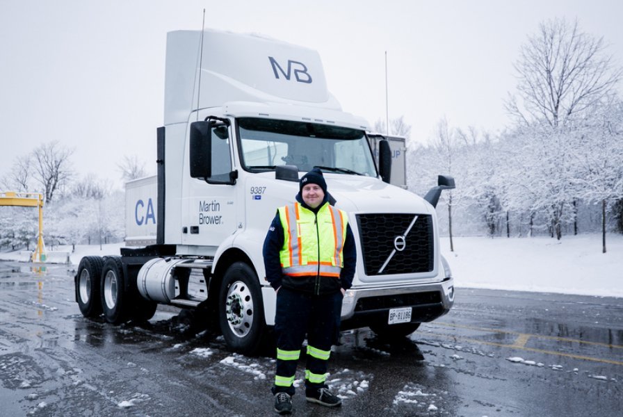 Company employee on the background of a truck in winter