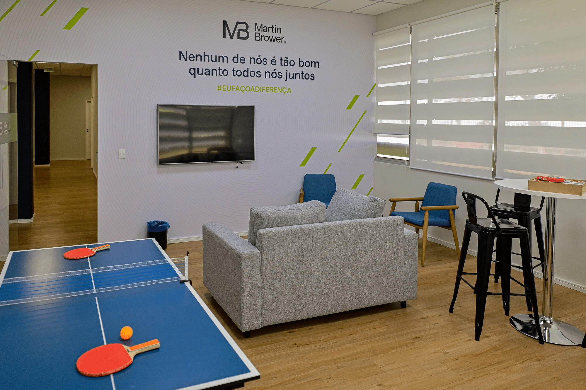 A small break area in the production facility - a sofa, chairs, a wall-mounted TV, and a ping-pong table in the corner