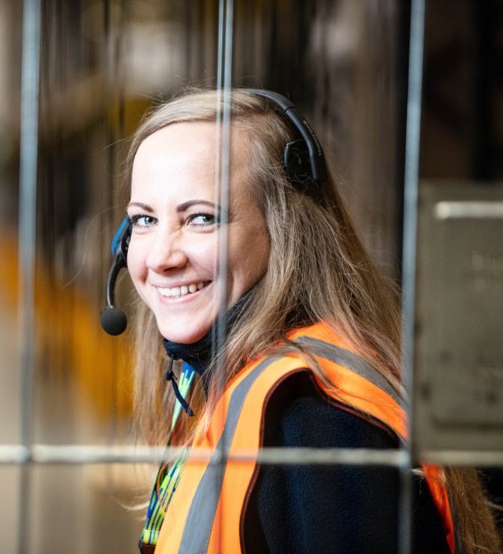 Woman in orange vest and headset smiling