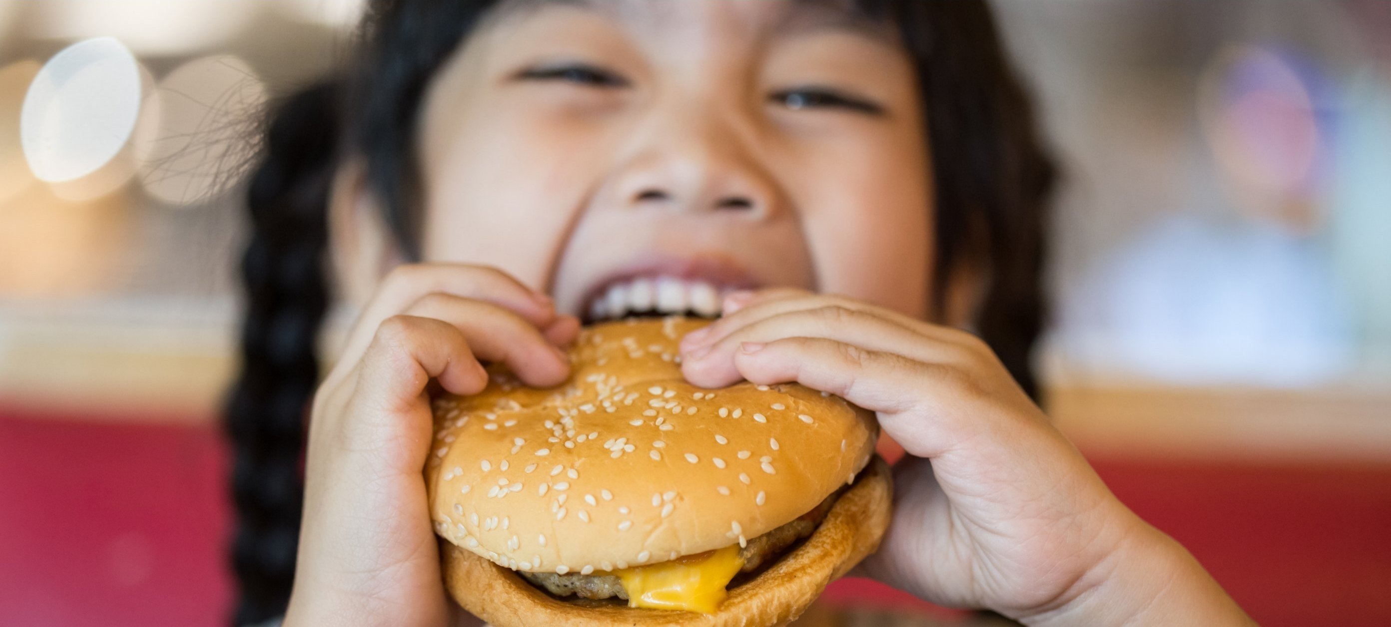 Girl eating cheeseburger