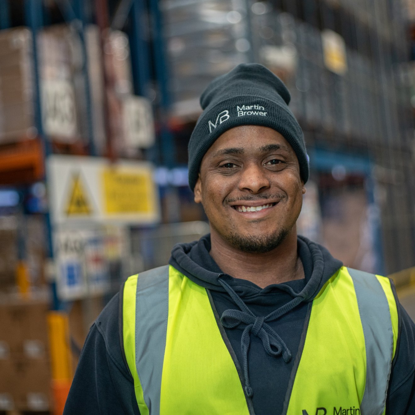 Smiling man wearing beanie in warehouse